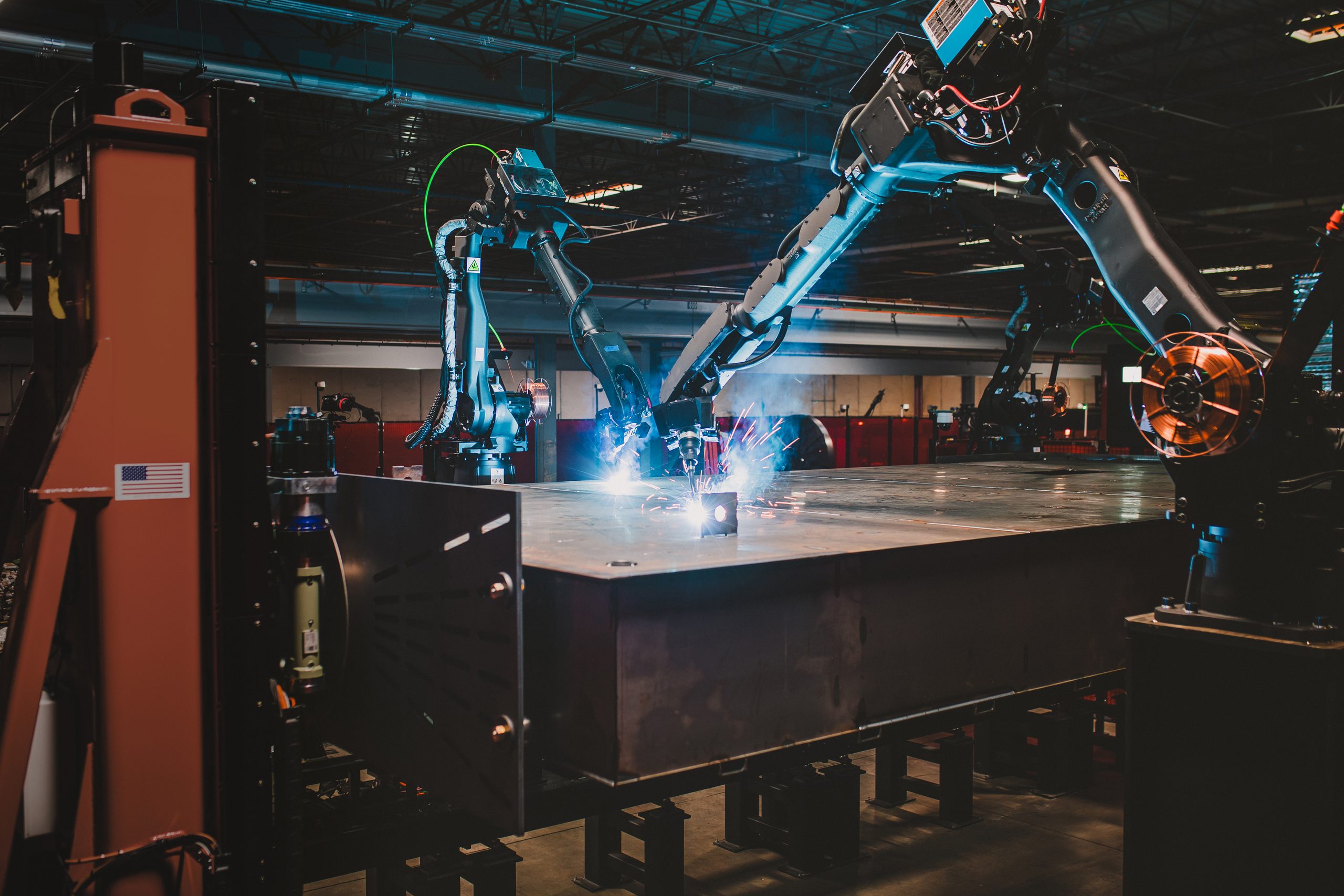 Dual robotic arms welding a large steel structure inside a Path Robotics Intelligent Welding Cell
